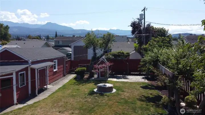Large lush backyard await you with a garage, and two storage buildings (one is quite large)