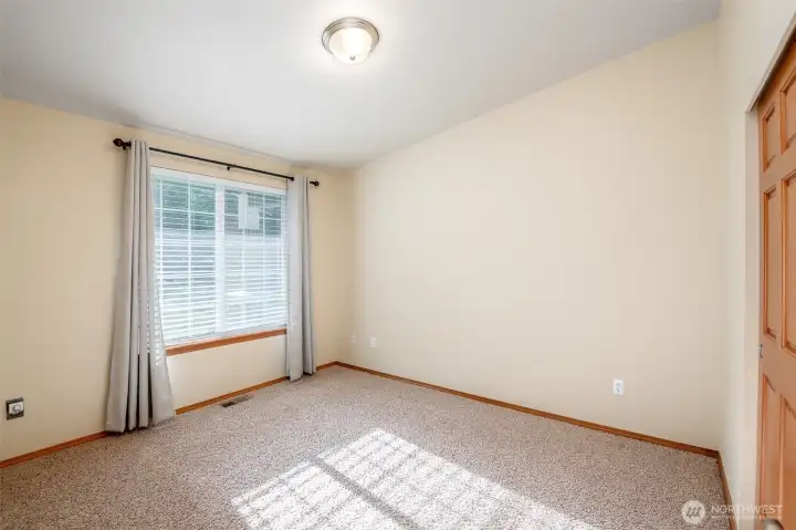 Second bedroom with plenty of natural lighting creates a warm and soft environment.