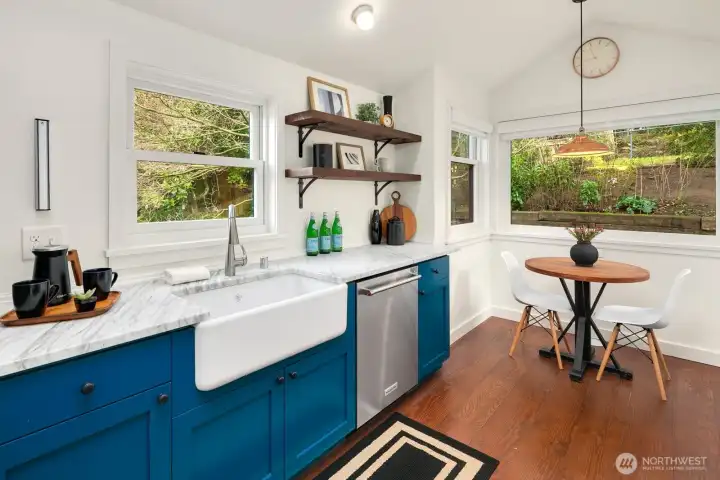 A stunning remodel of this kitchen with Carrera marble counters, Wolf Gas Range, farmhouse sink, designer lighting, counter seating and even a a breakfast nook overlooking the serene-quite backyard.