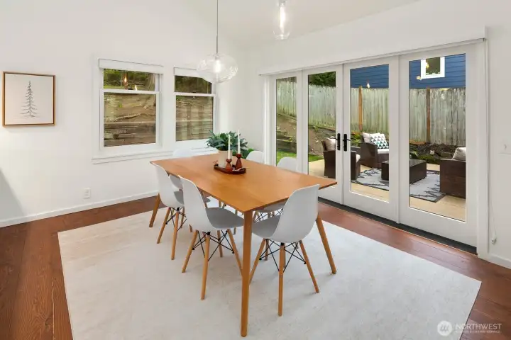 This bright living room was a thoughtful remodel with cathedral ceilings, surrounded by double paned windows, and designer lighting. French doors expand the interior living space to the deck and expansive back yard.