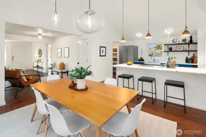 This bright living room was a thoughtful remodel with cathedral ceilings, surrounded by double paned windows, and designer lighting. French doors expand the interior living space to the deck and expansive back yard.