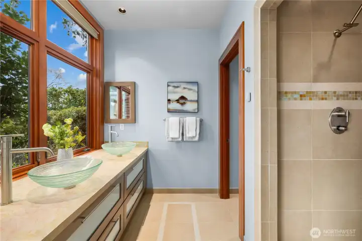 Light-filled and quietly refined, this ensuite bath blends clean lines with soft natural tones—where garden views, glass vessel sinks, and a walk-in shower create a calm, elevated daily ritual.