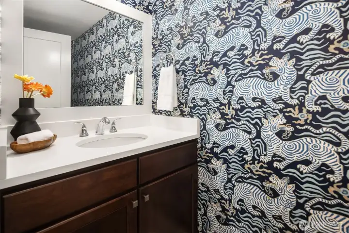 Custom wallpaper adorns the powder room in the living area.