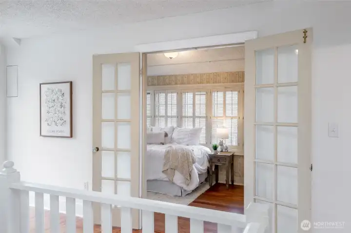 French doors open into a darling bedroom, full of charm