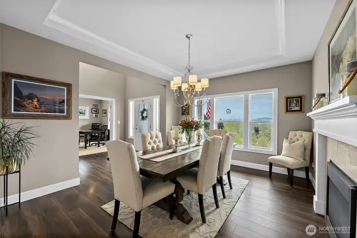 Striking dual sided fireplace and coffered accent lighting compliment the formal dining room.