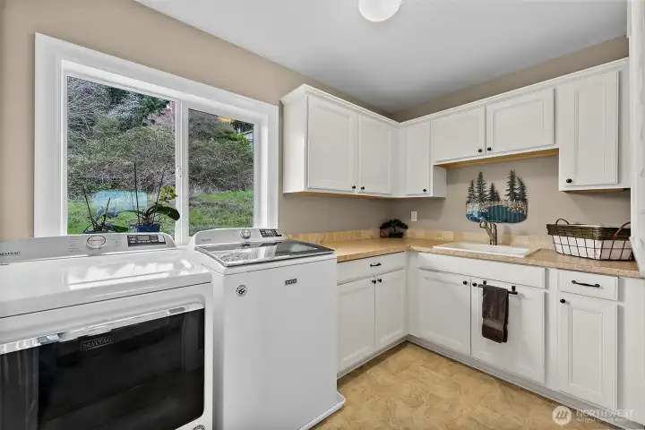 Utility room conveniently located upstairs with storage space & utility sink.