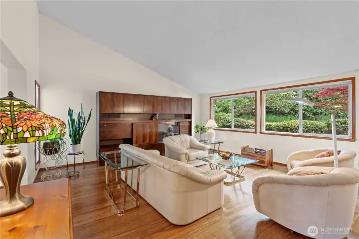 Enter to a vaulted ceiling living room with oversized picture windows