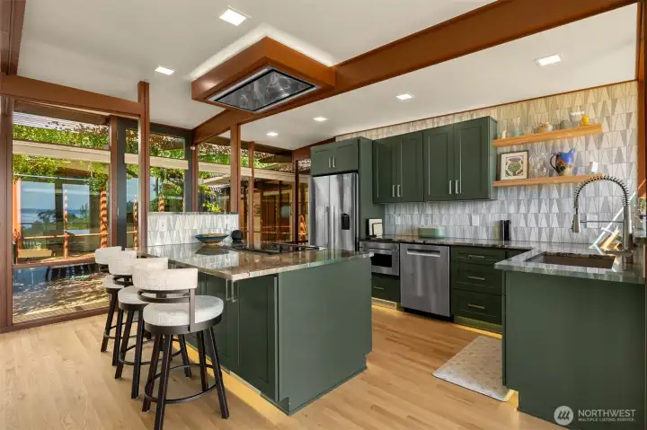 New center island bar with seating area. The kitchen also has custom tile work, display shelves, and all new appliances. New center island bar with seating area. The kitchen also has custom tile work, display shelves, and all new appliances.