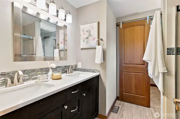 Spacious primary bathroom featuring dual sinks and modern fixtures. Spacious primary bathroom featuring dual sinks and modern fixtures.