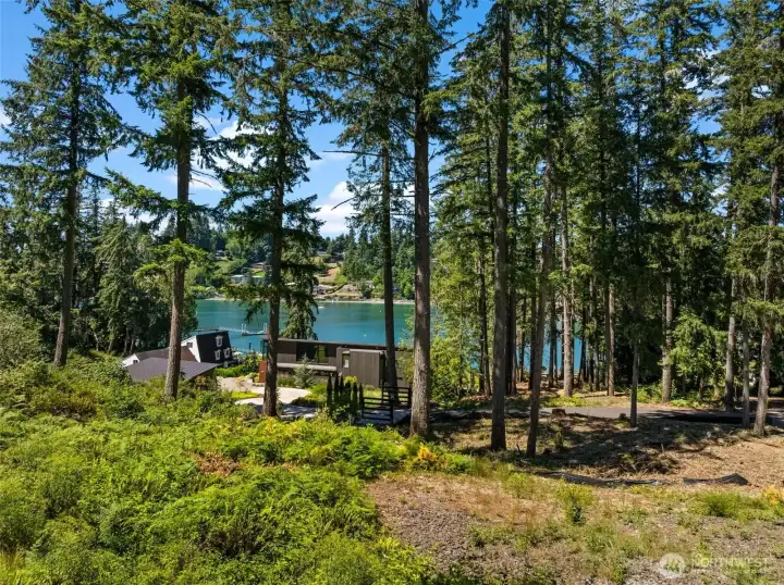 The property's wooded surroundings provide a scenic outlook toward the water and shoreline. The property's wooded surroundings provide a scenic outlook toward the water and shoreline.