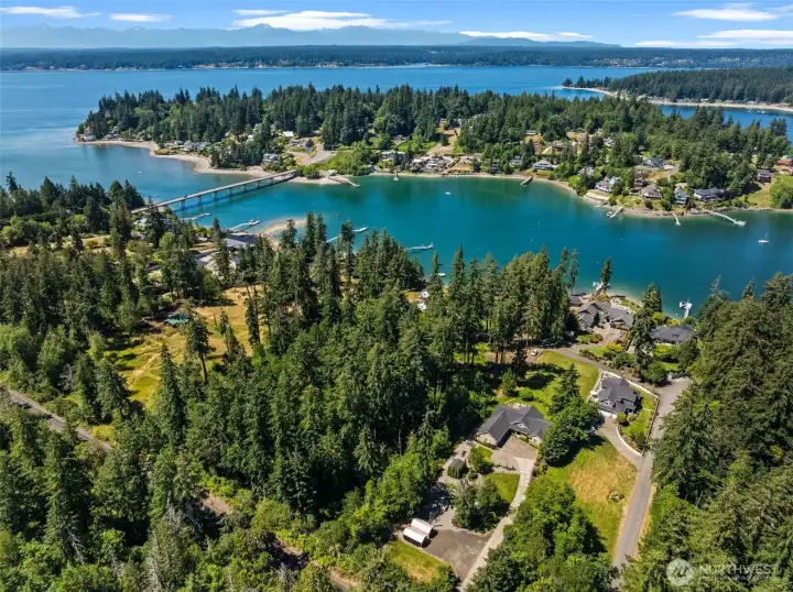 Bird's-eye perspective highlights the property's setting near the water and surrounding evergreen landscape. Bird's-eye perspective highlights the property's setting near the water and surrounding evergreen landscape.