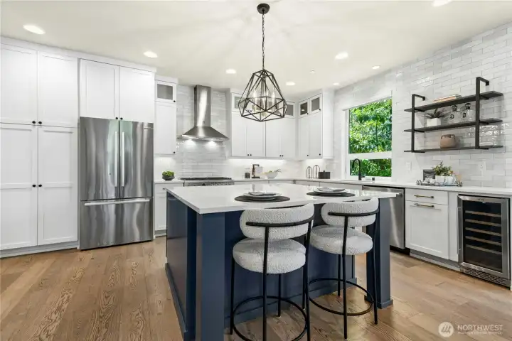 Wine fridge, 6 burner gas stove, quartz counters, and ample cabinet storage.