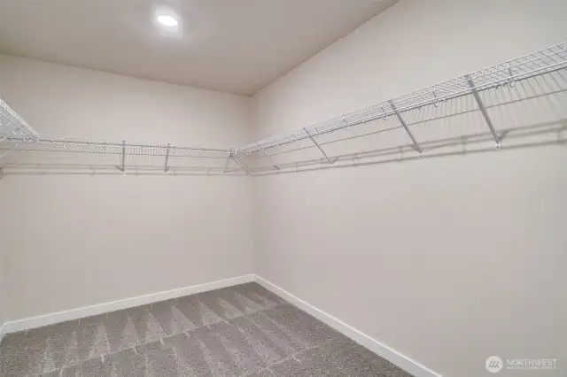 Photo not from actual home. Primary walk-in closet