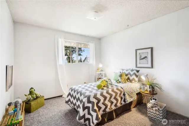The first guest bedroom of the main level looks out over the front yard.