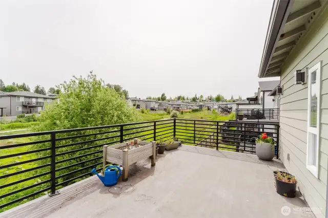 South facing deck off primary bedroom is a wonderful and peaceful place to enjoy the natural green space behind the home