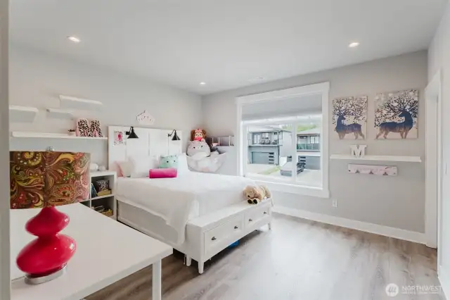Second upstairs bedroom with tall ceilings and large window