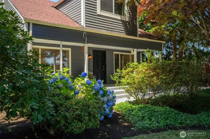 Charming curb appeal with fresh exterior paint, mature landscaping, and a welcoming front porch.