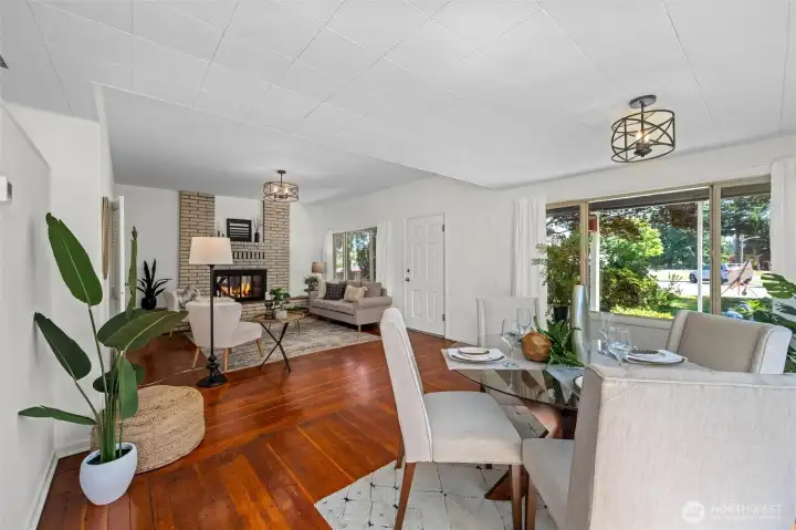 This bright and welcoming living space blends comfort and style, featuring original hardwood floors, large picture windows, and a cozy fireplace.