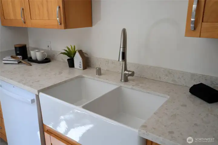 A close-up of the deep, double-basin farmhouse sink and sleek pull-down faucet—designed for both beauty and function.