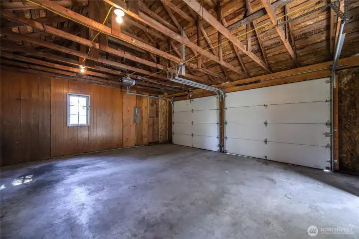 Oversized two-car garage with vaulted ceilings and workbench space—ideal for projects, storage, or hobbies.
