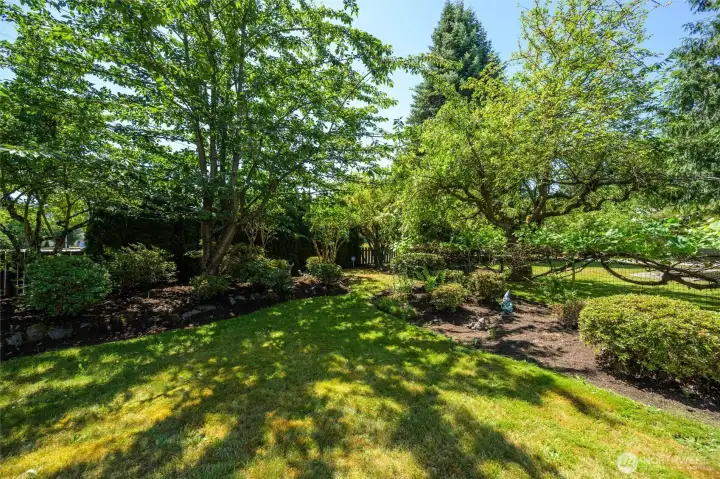 A lush, level yard with space to play, garden, or simply unwind under the canopy of old-growth trees.