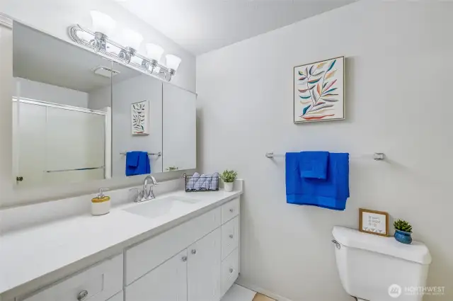 Primary Bathroom. Newly updated with beautiful vanity featuring lots of storage and a sleek quartz countertop. Light and bright and a wonderful way to start your day.