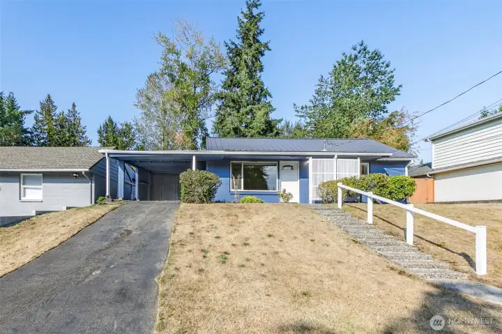 Large driveway with deep carport & storage closets; gate into backyard