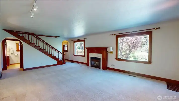 Expansive living room with wood wrapped windows.  There are the original hardwood floors beneath the carpet too!