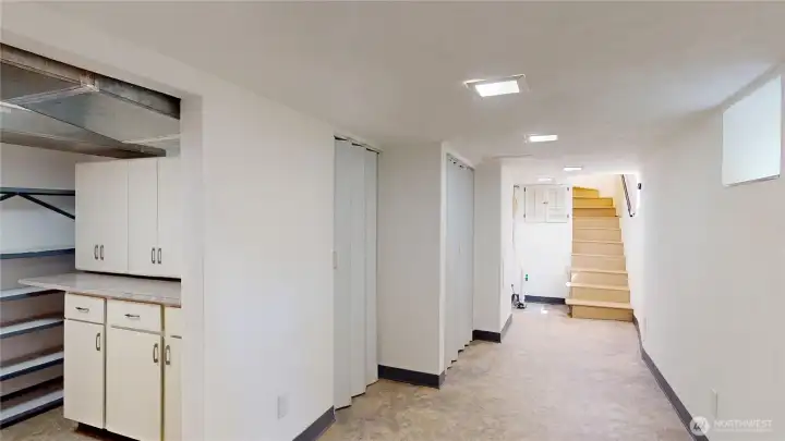Downstairs basement looking towards stairs.  There is loads of storage here and areas for crafts, canning etc. There is a half bath near the stairs, furnace and hotwater heater are off to the left behind corrigated doors.  this home has an energy efficient heat pump and newer hot water heater.  The stairs lead up to the kitchen and there is a landing where the door to the back yard is.