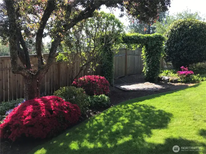 The yard boasts colorful, mature landscaping