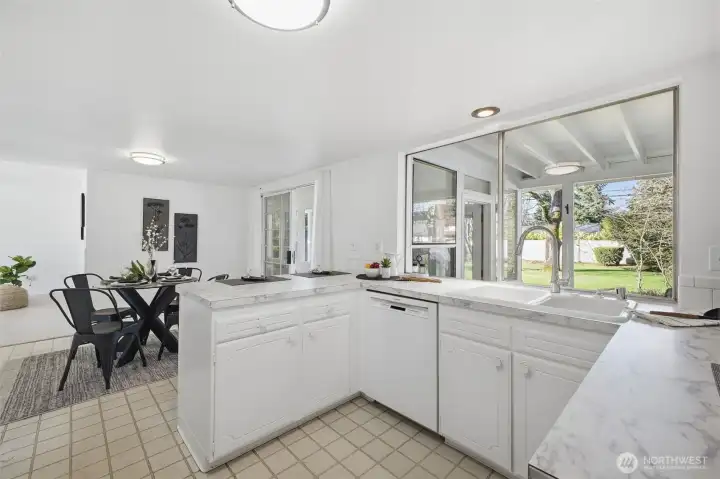 Bright and inviting, the kitchen opens to the backyard through a large window, bringing in sunlight and connecting the space to outdoor living.