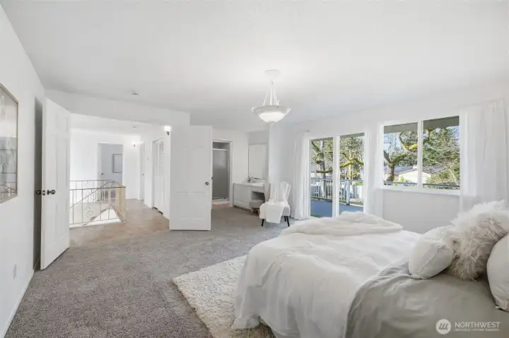 This tranquil primary bedroom features double doors and a sliding door with access to the balcony.