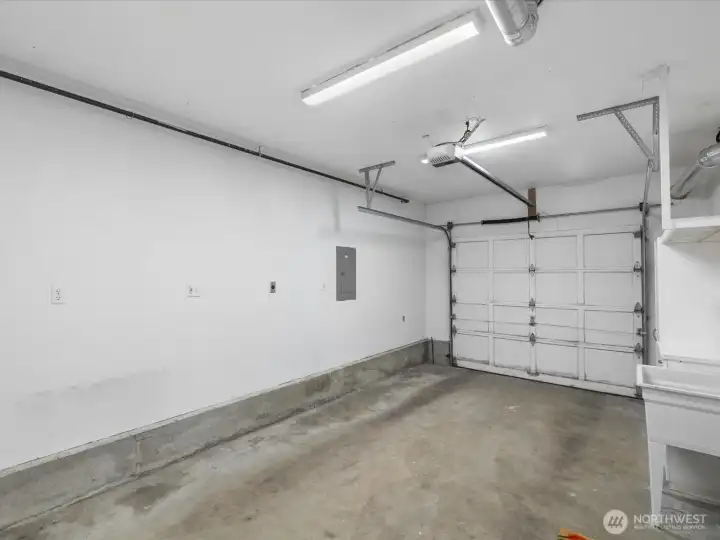 The garage includes a sink, door opener and closet with water heater and furnace.