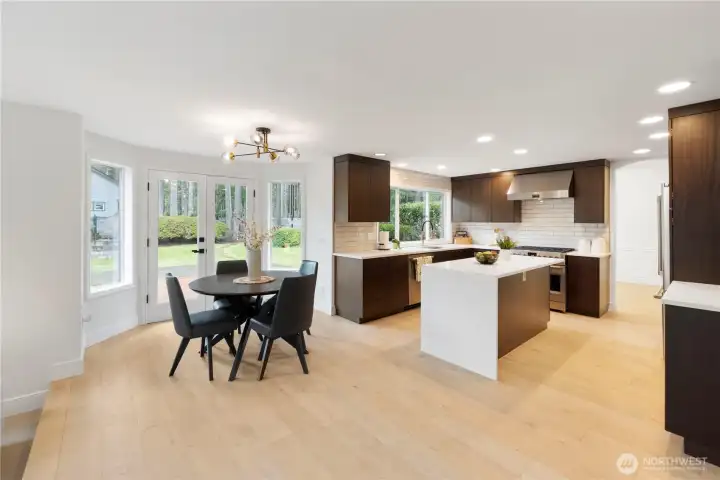 Gourmet kitchen featuring brand-new cabinetry with an abundance of thoughtful storage and built-in features. Enjoy upgraded appliances—all included—highlighted by a sleek European-style gas range and designer hood fan. The spacious island offers a convenient microwave/convection oven combo, perfect for modern living. A full tile backsplash adds a touch of elegance, tying the entire space together. This kitchen truly blends style, function, and high-end finishes—plus so much more to discover!