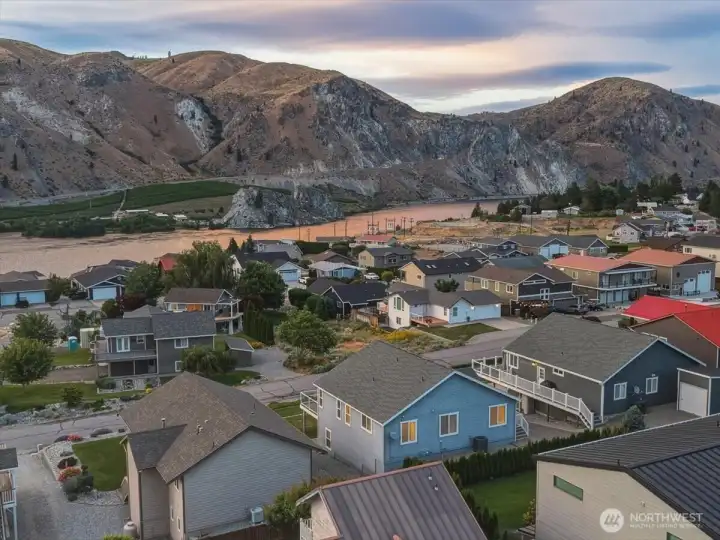 Aerial view of home overlooking the river and community waterfront with clubhouse, sports courts, pool, boat launch, marina, playgrounds and more.
