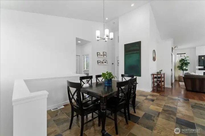 View 1 of dining room adjacent to kitchen and living room with slate tile flooring, vaulted ceilings and brand new interior paint.