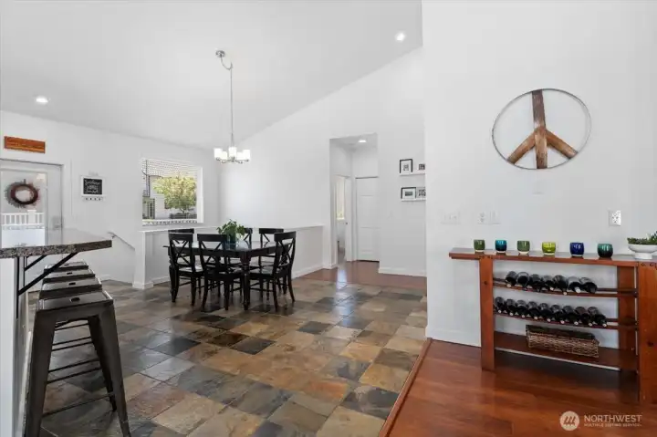 View 2 of dining room adjacent to kitchen and living room with slate tile flooring, vaulted ceilings and brand new interior paint.