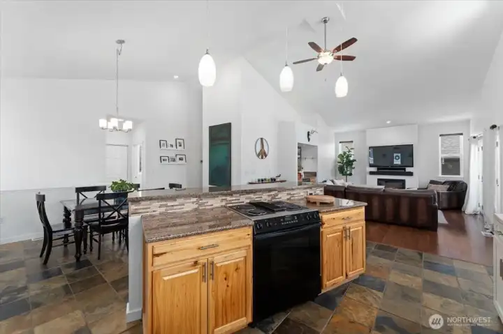 View of kitchen looking towards dining room and living room with slate tile flooring, vaulted ceilings and brand new interior paint.