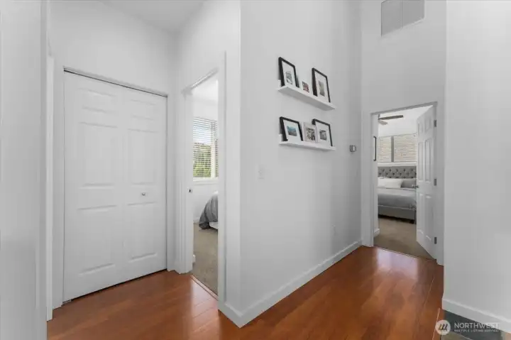 View of main level hallway leading to the Primary Bedroom Suite and two additional bedrooms and full bathroom.