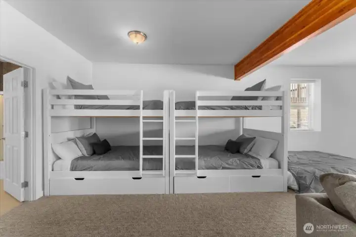 View 2 of Lower Level Bonus/Media room with bunk beds and sliding glass doors leading to the Lower Level outdoor living area.