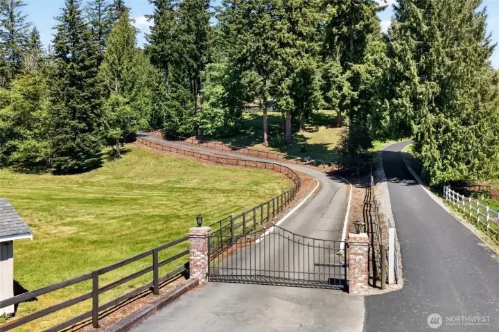Arrive in style through the elegant gated entrance, where attractive three-rail fencing frames the paved driveway. This private drive serves only two homes, enhancing the property's sense of privacy and exclusivity.