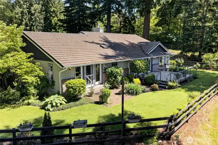 Relax and unwind in this inviting backyard setting featuring a spacious deck, vibrant gardens, and meticulously maintained landscaping. The primary suite enjoys private outdoor access, while the tile roof provides timeless beauty and durability.