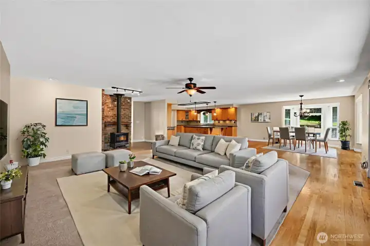 Virtually staged to inspire, this expansive open-concept space showcases seamless flow between the living and dining areas. Beautiful hardwood floors and a cozy gas stove create warmth and comfort, making it an ideal gathering place for family and friends.