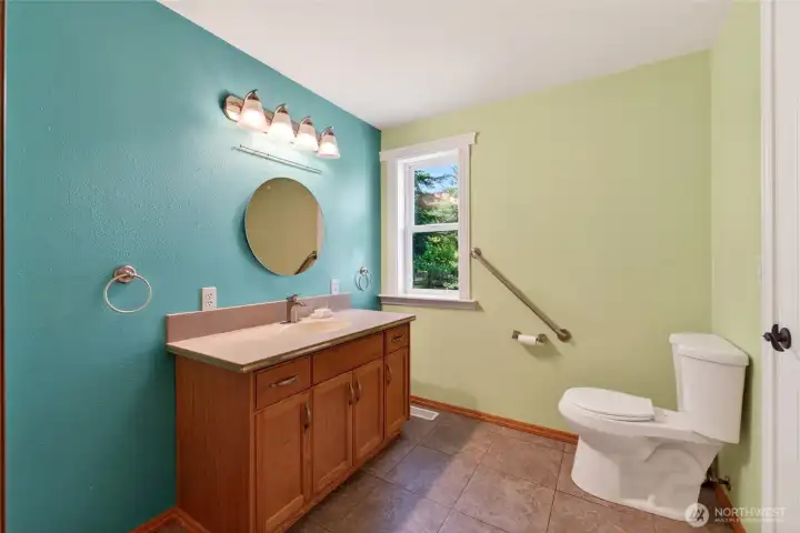 A spacious half bath is conveniently located just off the garage entrance, adjacent to the utility room and kitchen for easy everyday access.