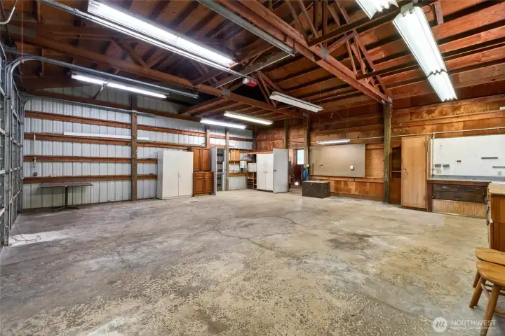 The first two bays provide expansive, flexible space, complemented by a rear man door leading to a grooming area and a far-left entry opening into a third large bay.
