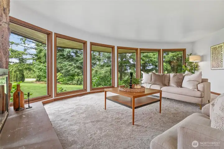 The living room features a solarium of windows that bring an abundance of natural light in to fill this enjoyable space.