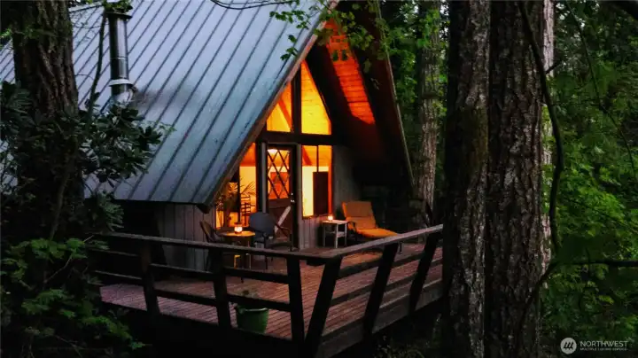 Charming a-frame style with open sleeping loft, great wall of windows, cozy fireplace and large deck overlooking your private riverside garden.