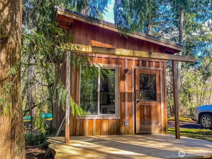 The Host Cabin with sleeping loft, kitchen with gas cooktop, living room and shower.