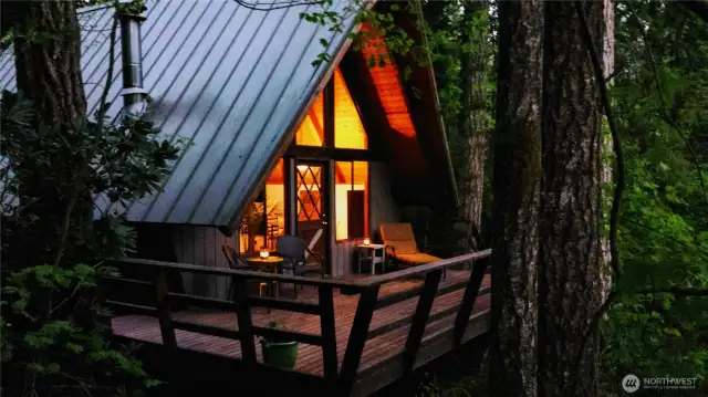 Charming a-frame style with open sleeping loft, great wall of windows, cozy fireplace and large deck overlooking your private riverside garden.