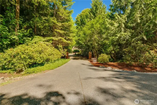 Stately gated entry framed by lush, mature landscaping and timeless allure.